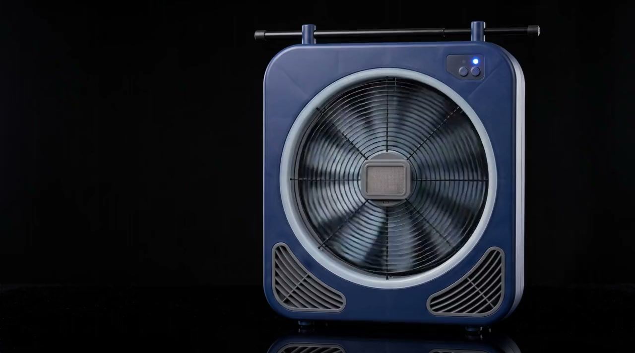 Messgebläse einer Blower-Door-Anlage vor schwarzem Hintergrund: dunkelblaues Gehäuse mit Axialventilator hinter Schutzgitter, seitlichen Lüftungsgittern und Teleskopstange.